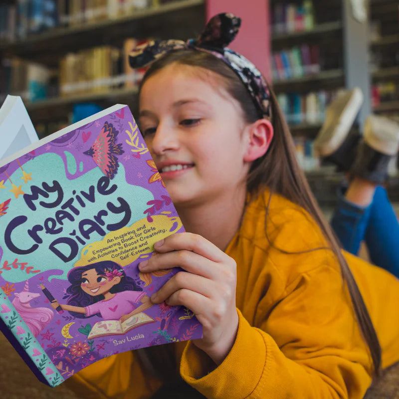 A girl smiles as she reads My Creative Diary