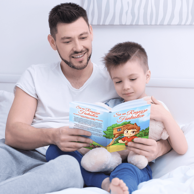Un bambino sorridente legge Sei un Ragazzo Fantastico all’aperto.